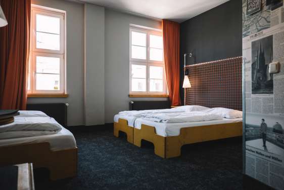 Single and double bed in the hotel room of the Superbude.
