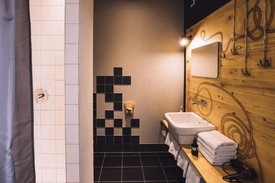Large bathroom with dark tiles and a big washbasin.