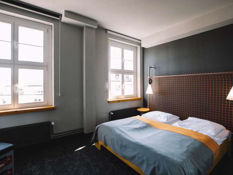 Lichtdurchflutetes Hotelzimmer mit großem Bett.