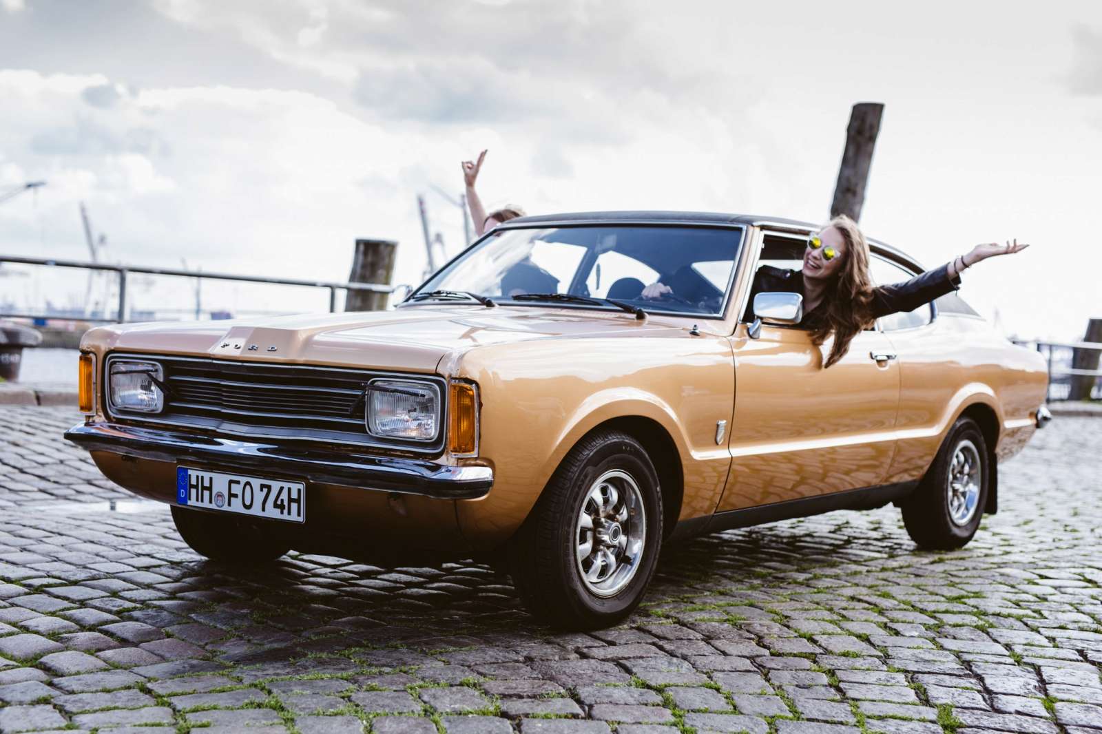 Oldtimer am Hafen - zwei Frauen schauen aus den Fenstern.