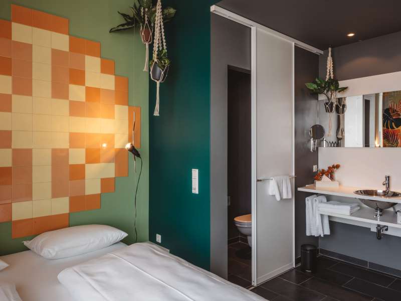 Doppelbude mit Pixel-Kunst an der Wand und offenem Bad.