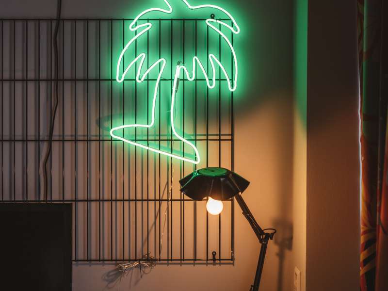 Neon-Palme leuchtet über dem Schreibtisch in der Superbude Altona.