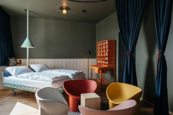 Minimalistische Einrichtung mit Stühlen und Bett in der Supersense Suite.